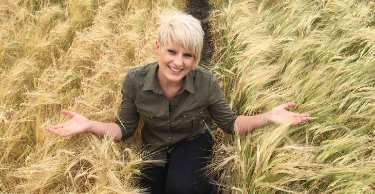 A woman poses in a barley field during for 