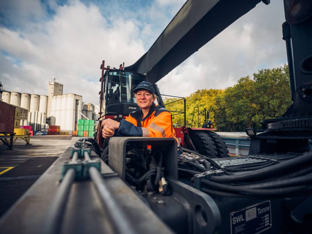 A logistics operator sits on heavy equipment at the malt production site, ready for cargo handling operations.