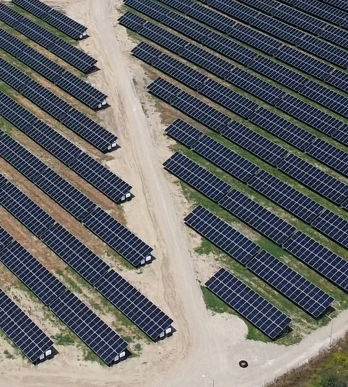 Rows of solar panels stretch across a large green field, highlighting how Soufflet Malt supports regenerative agriculture