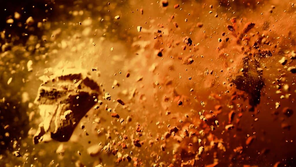 Chocolate pieces burst into fine cocoa particles, highlighting the bold flavours created through innovative food ingredients solutions from a chocolate malt supplier.
